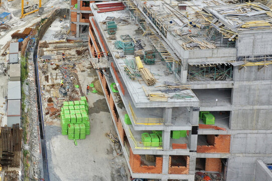 Aerial view of a large construction site with workers, concrete structures, and green building materials in Avcilar, Istanbul, Turkiye.