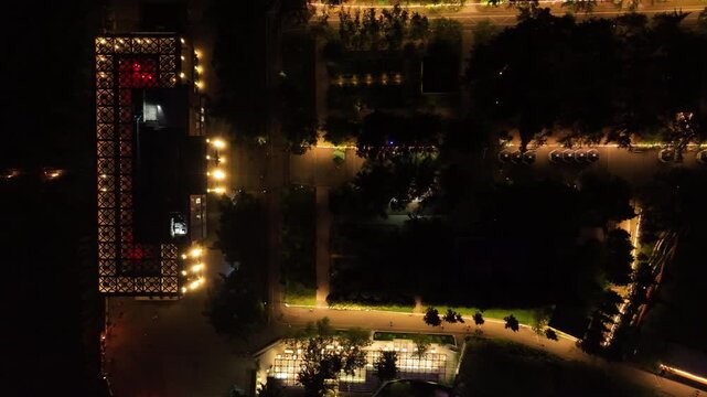 Aerial night view of Mtatsminda Park restaurant and funicular station in Tbilisi, Georgia, featuring illuminated arched architecture