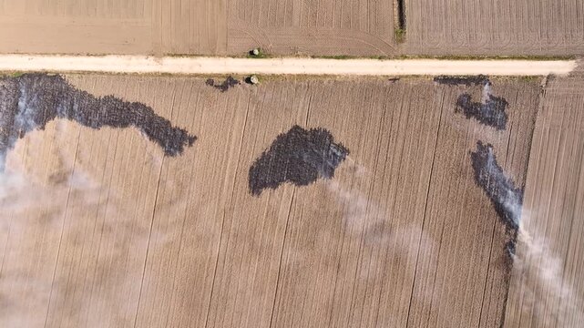 In a vast agricultural region, flames rage across parched fields, releasing thick smoke into the air. This fiery event highlights the devastating truth of drought and climate changes impact.