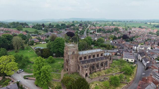 The stunning St Oswald&rsquo;s Church and surrounding Malpas village - drone rotate and pull back from near, Cheshire, UK