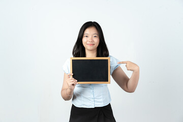 Fototapeta premium Happy Asian woman pointing at blank chalkboard frame for advertising and marketing