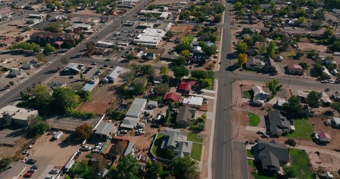 Low aerial overview above Kanab Utah homes and streets surrounded by red desert landscape, drone background for real estate