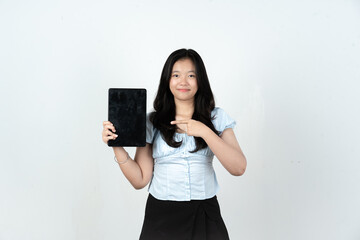 Naklejka premium Portrait of Asian woman holding and pointing at blank tablet on white background