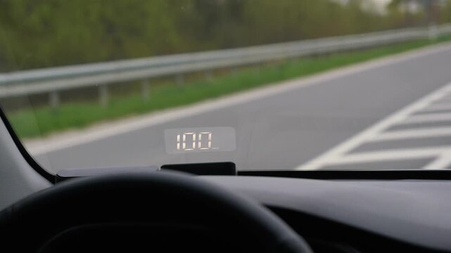 electronic speedometer in a car on the windshield during a trip. speed 100 - 110 km per hour. travel, technology