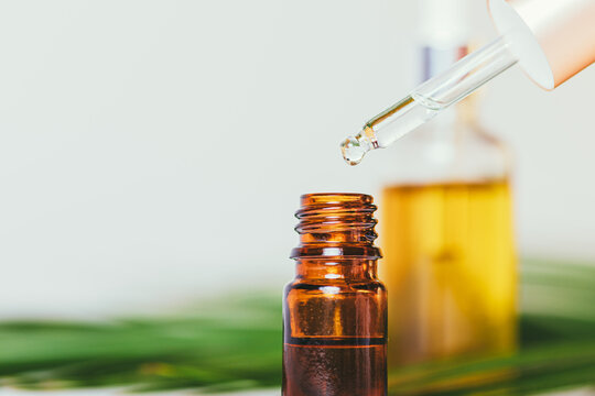 Essential oil being carefully dispensed into an amber glass vial