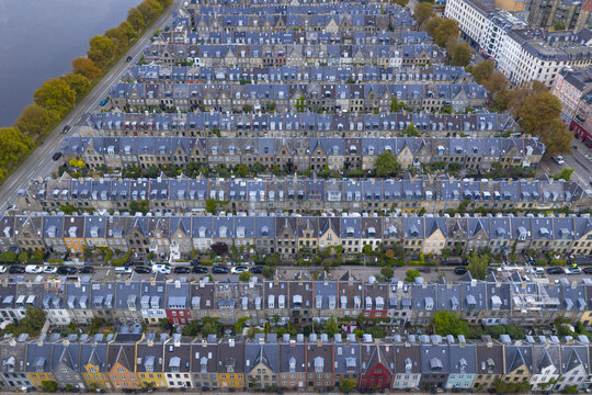 Aerial view of Kartoffelraekkerne historic terraced houses with uniform rooftops and colorful facades near the lakes in Copenhagen, Denmark.
