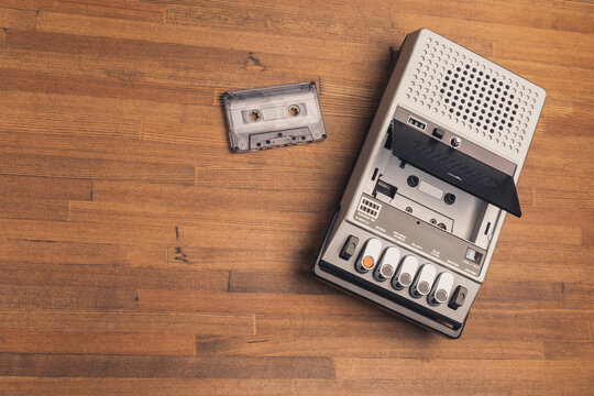 Vintage cassette recorder and tape on wooden surface