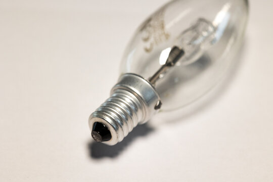 Close-up light bulb. White background, electricity equipment, transparent glass, metal.