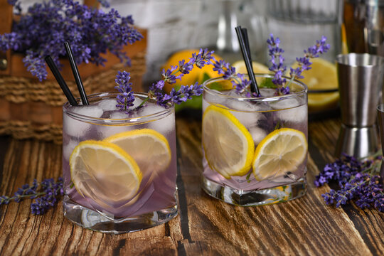 Margarita cocktail with lavender flavor. Garnished with lemon wedges and lavender sprigs