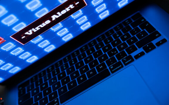 Close-up of a laptop screen, virus alert information, computer crime. Safety, data protection, privacy, computer hacked, system configuration, fire wall.
