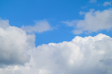 Obraz premium Bright blue sky filled with fluffy white cumulus clouds on a sunny day
