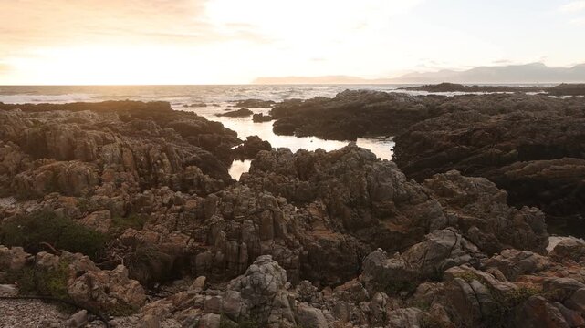 sunset light over rocky coastline of DeKelders, Gansbaai, South Africa
