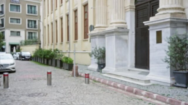 Soft defocused istanbul street scene showing blurred building facade, planters and cobblestone foreground; background backplate copyspace template.