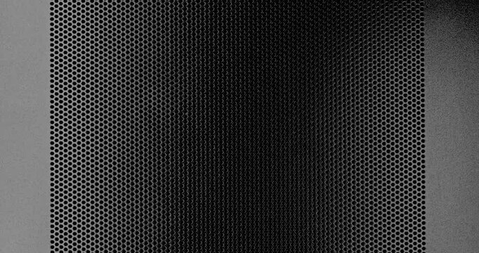 Perforated Metal Surface. A black perforated surface with a repeating pattern of holes creates a textured, industrial look.