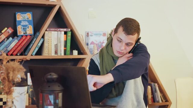 White student tired at laptop desk, bookshelf backdrop, rubbing eyes and stretching arm, slouching posture showing fatigue, lamp glow and latenight ambience, freelancer writer facing deadline pressure