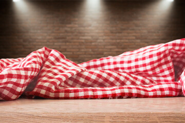 Obraz premium Checkered Picnic Fabric Isolated on Brick wall with spot lights Background