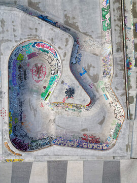 Aerial view of a concrete skatepark bowl covered in vibrant graffiti art and street tags Brussels, Brussels, Belgium.