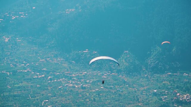 Group of paragliders at Manali in Himachal Pradesh, India. Tourist enjoying adventure activity during summer vacation. 