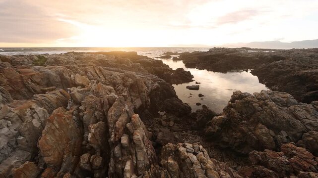 sunset light over rocky coastline of DeKelders, Gansbaai, South Africa