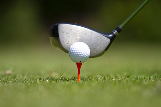 View of a white golf ball resting on a red tee with a driver club positioned for a swing on a lush green course in Tiwi, Wilaya ya Kwale, Kenya.