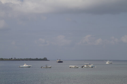 View of small boats anchored in the calm ocean waters near the shoreline of Tiwi Beach, Tiwi, Wilaya ya Kwale, Kenya.