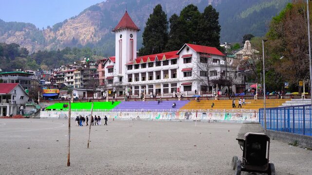 Panoramic view of the historic Clock Tower and colorful stands at The Flats in Nainital, India