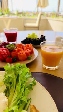 Rich all inclusive breakfast with mango juice, fresh strawberry, salmon and basturma meat on luxury 5-star hotel terrace in Sharm El Sheikh. Lavish chic food styling at resort buffet in Egypt.