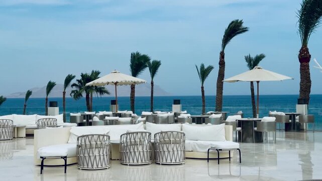 Luxury 5-star hotel resort outdoor lounge cafe terrace with white designer furniture in Sharm El Sheikh. Beautiful Red Sea view restaurant of premium all inclusive holiday destination in Egypt.