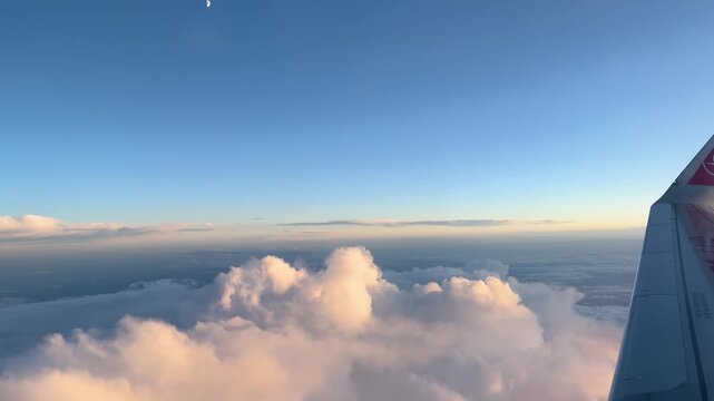 Sunset Clouds and a View of the Moon from an Airplane Window.