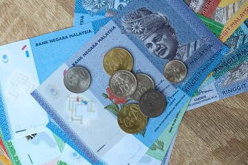 Malaysian ringgit money bills and coins on table. Malaysia cash of MYR currency close up © Larysa
