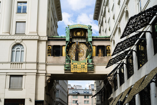 View of the historic Anker Clock with its intricate Art Nouveau design and golden figures bridging two white buildings under a bright sky Vienna, Vienna, Austria.