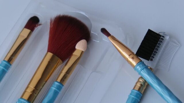 Close up of cosmetic makeup brushes set with blue handles on a white background