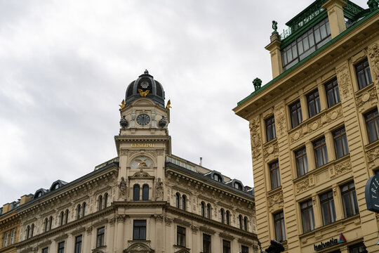 View of the historic Generali building featuring an ornate clock tower and dome under an overcast sky in Vienna, Vienna, Austria.