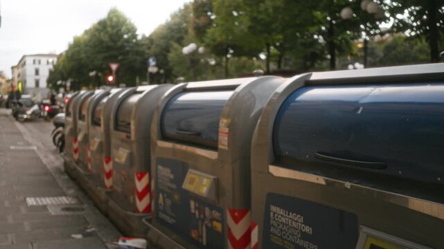 Row of blurred garbage containers on the soft street background; backplate copyspace background calm.