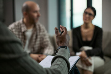 Middle aged couple attending counseling session, listening during divorce mediation with therapist taking notes. Ideal for relationship conflict, separation support, legal guidance marketing