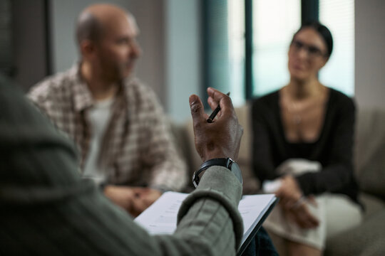Middle aged couple attending counseling session, listening during divorce mediation with therapist taking notes. Ideal for relationship conflict, separation support, legal guidance marketing