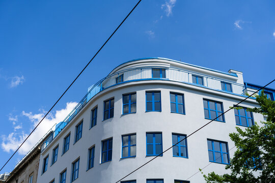 View of a modern white building with blue window frames and a curved facade under a clear blue sky in Bratislava, Bratislava Region, Slovakia.