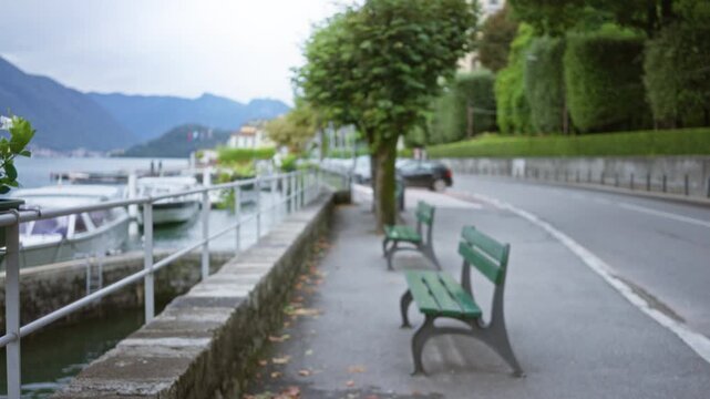 Lakeside promenade and harbor walkway showing blurred bokeh benches and shallow defocused foreground, street; background backplate copyspace calm.