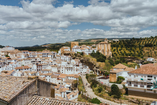 Aerial panoramic view of Setenil de las Bodegas white village in Andalusia Spain under dramatic clouds