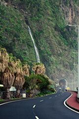 Fototapeta premium Scenic Coastal Road in Madeira with Waterfall and Tunnel Entry Madeira island, Portugal landscape