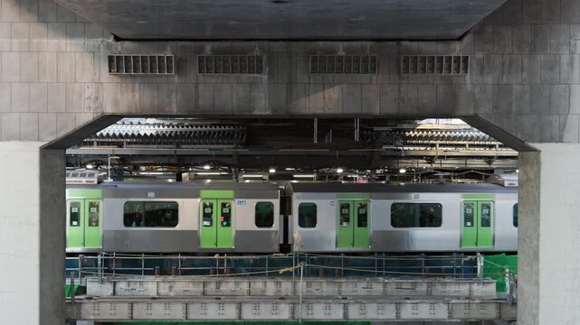 Tokyo Scene  :  Commuter Train Departing From Station Platform in a Framed View Between Concrete Highway Supports, Exposed Layered Structure of Urban Redevelopment  |  Shibuya Station, Tokyo, Japan