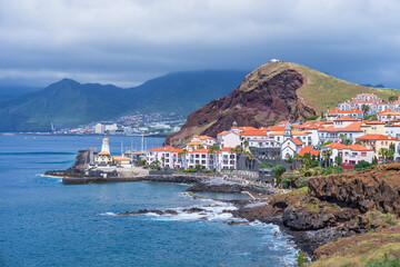 Fototapeta premium Scenic view of Quinta do Lorde resort and marina with a lighthouse on the volcanic coast of Ponta de Sao Lourenco, Madeira, Portugal