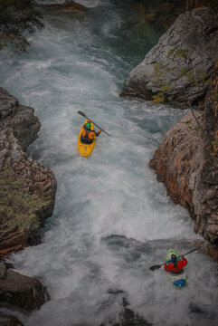 View of kayakers navigating the white water rapids of the Rio Manso through a narrow rocky canyon in San Carlos de Bariloche, Rio Negro, Argentina.