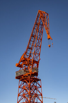 View of the historic red Carola crane standing tall against a clear blue sky at the maritime museum docks in Greater Bilbao, Basque Country, Spain.