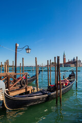 Fototapeta premium Traditional Venetian Gondolas Moored at Molo San Marco with San Giorgio Maggiore Island in the Background, Venice, Italy