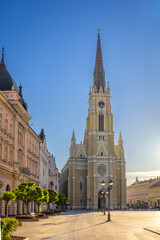 Fototapeta premium Novi Sad Old Town Square With Neo-Gothic Cathedral And Historic Architecture Under Clear Blue Sky In Serbia