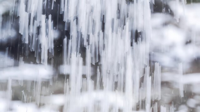 Abstract vertical streaks of white and grey water create a dynamic, flowing, and ethereal background texture.