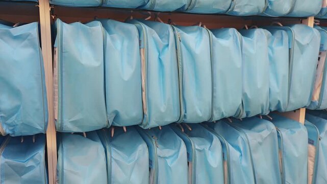 Blue fabric bags for packing silk blankets and pillows are lined up in rows in the warehouse, ready for sale