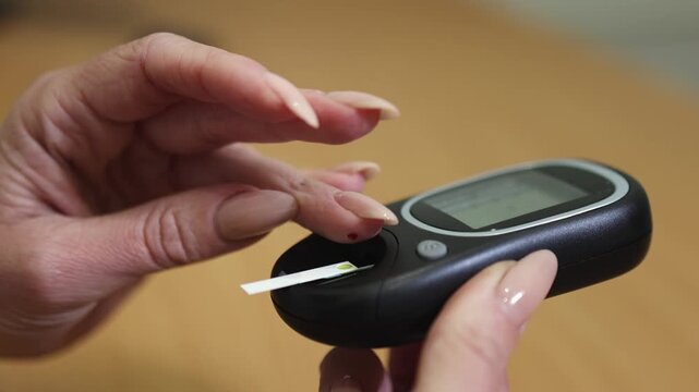 Glucometer. Woman's finger. Drop of blood. Applying finger. Slow motion video. High quality 4k footage