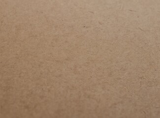 Fototapeta premium Closeup of textured brown paper surface. Natural organic fibers create a warm matte background with subtle grain and detail. Ideal for rustic crafts or vintage design elements.